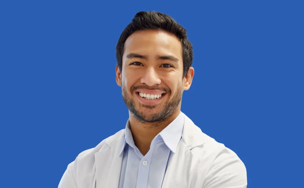 A man in a white lab coat on a blue background.