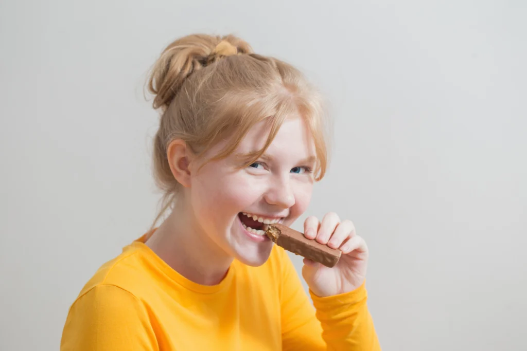 A girl eating a chocolate bar.