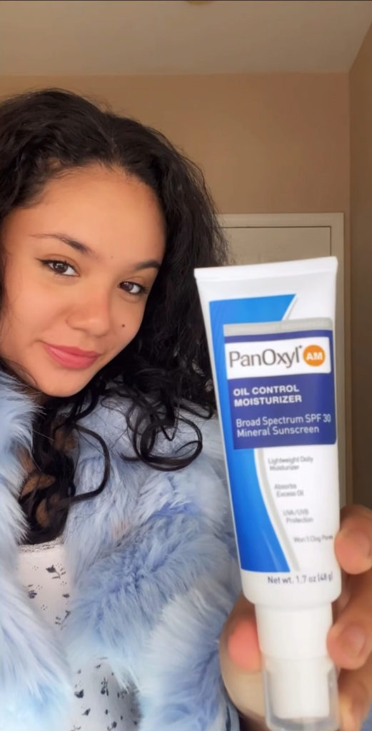 Young lady holding PanOxyl Oil Control Moisturizer