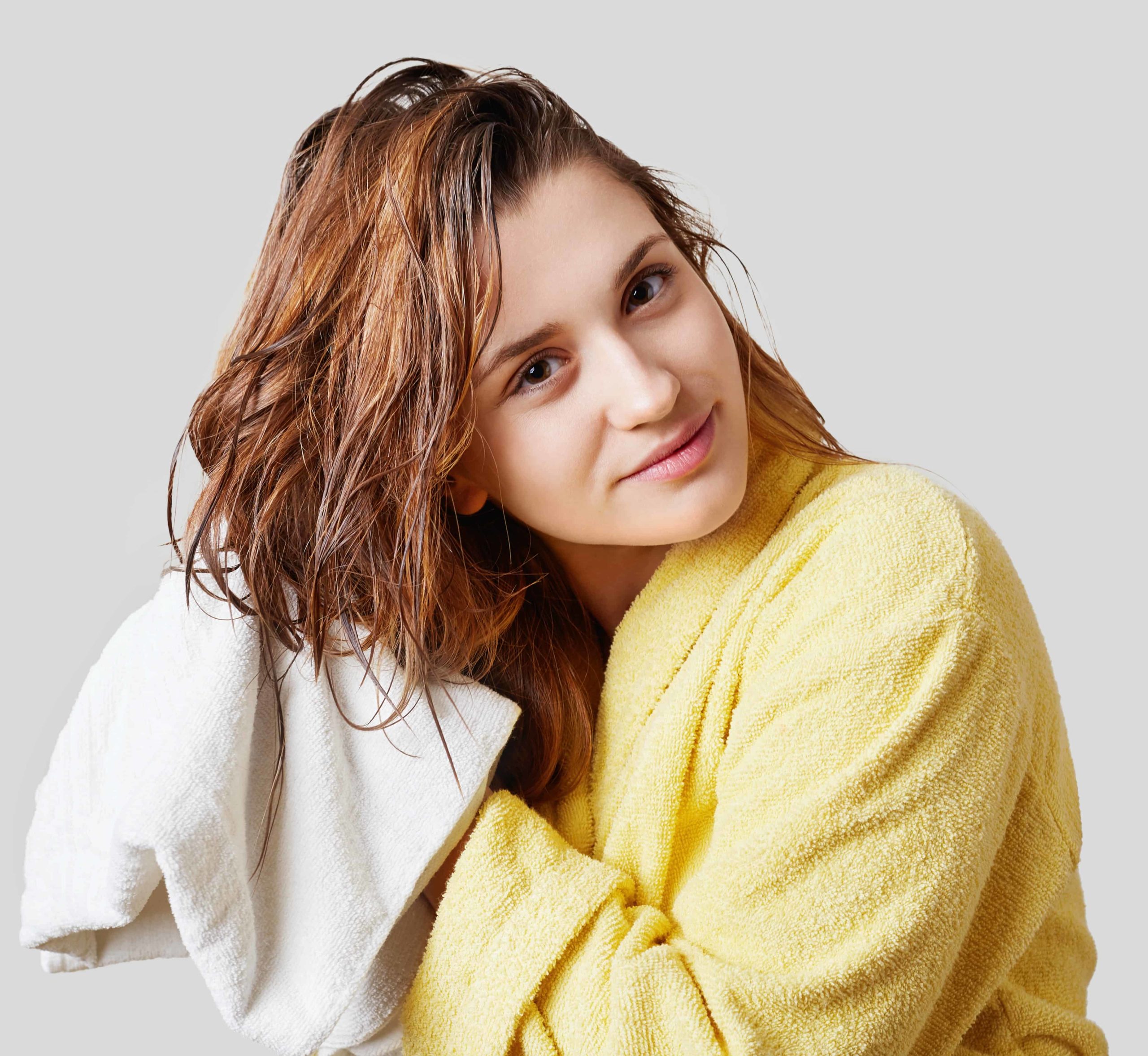 Woman drying her wet hair with a towel