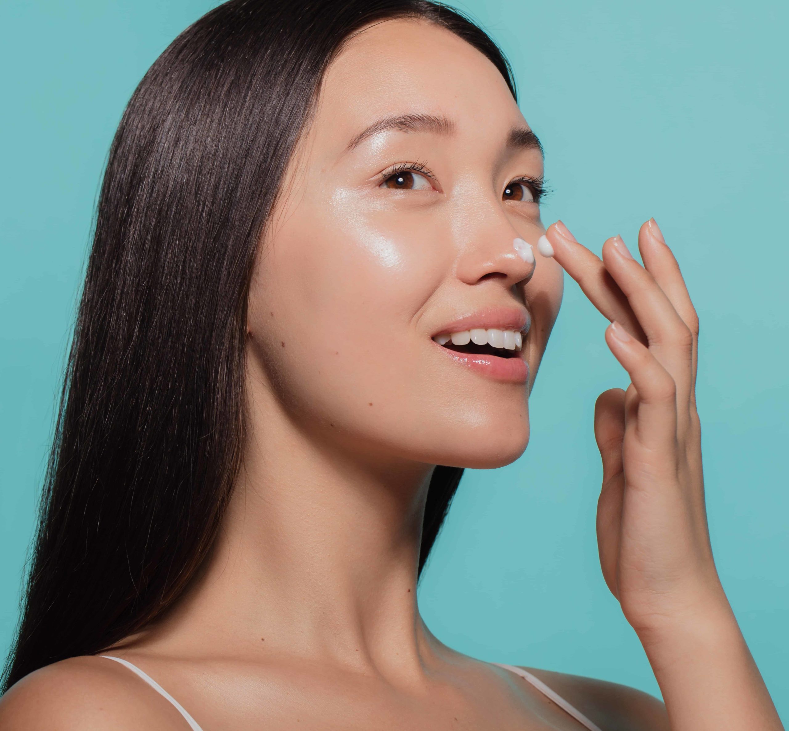 Woman applying moisturizer to her face