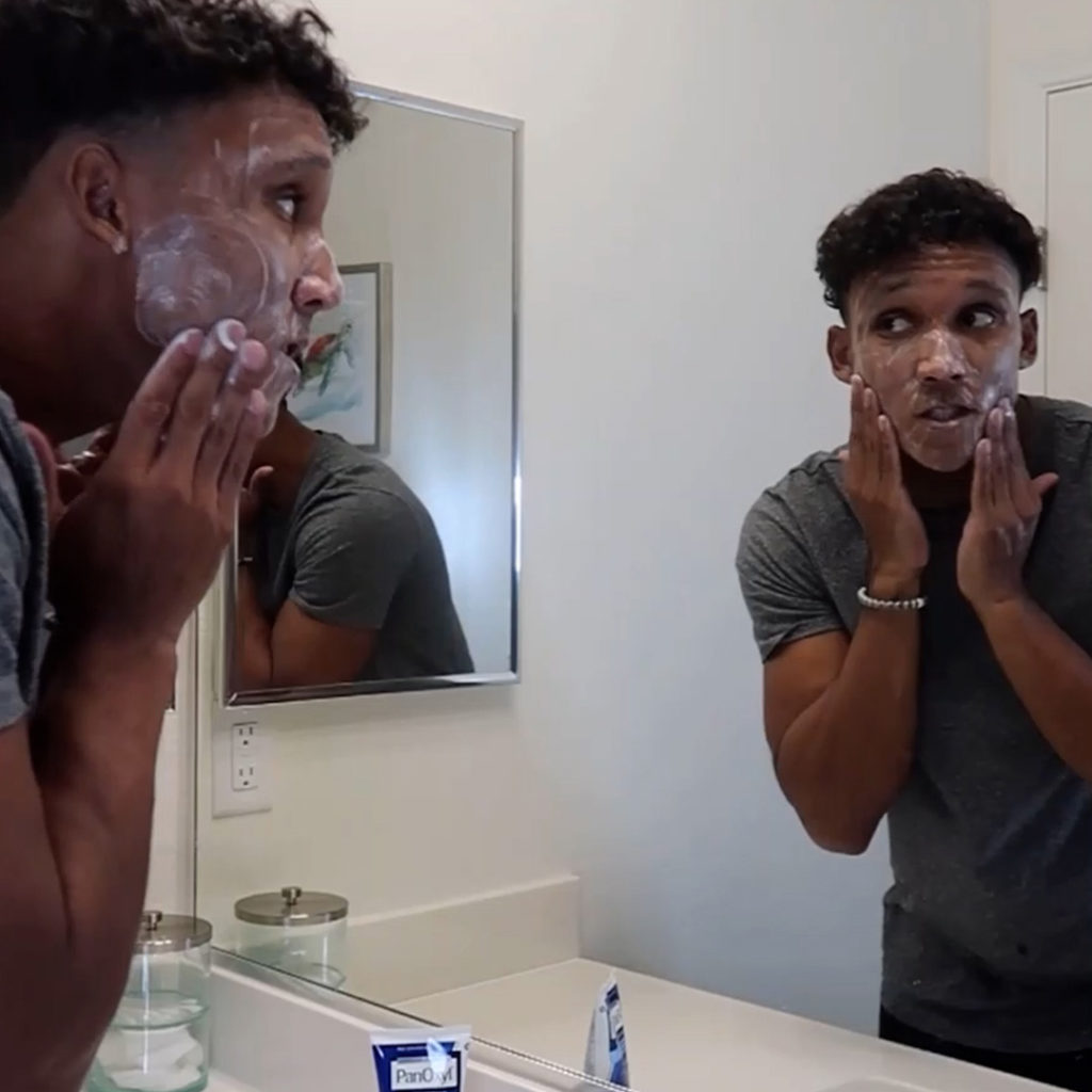 Quentin Hank applies PanOxyl Acne Creamy Wash to his face.