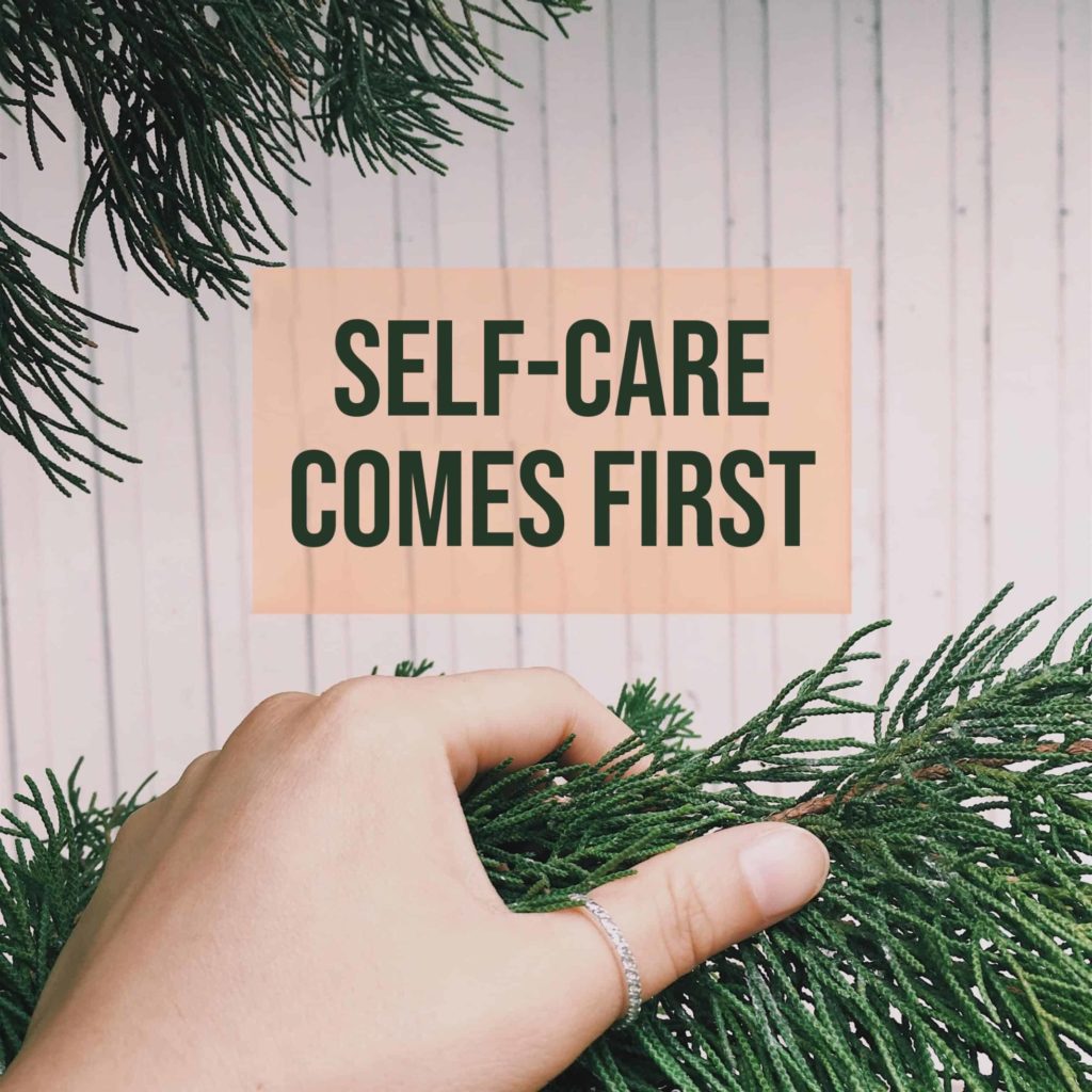 Text: Self-care comes first with fir branches surrounding it