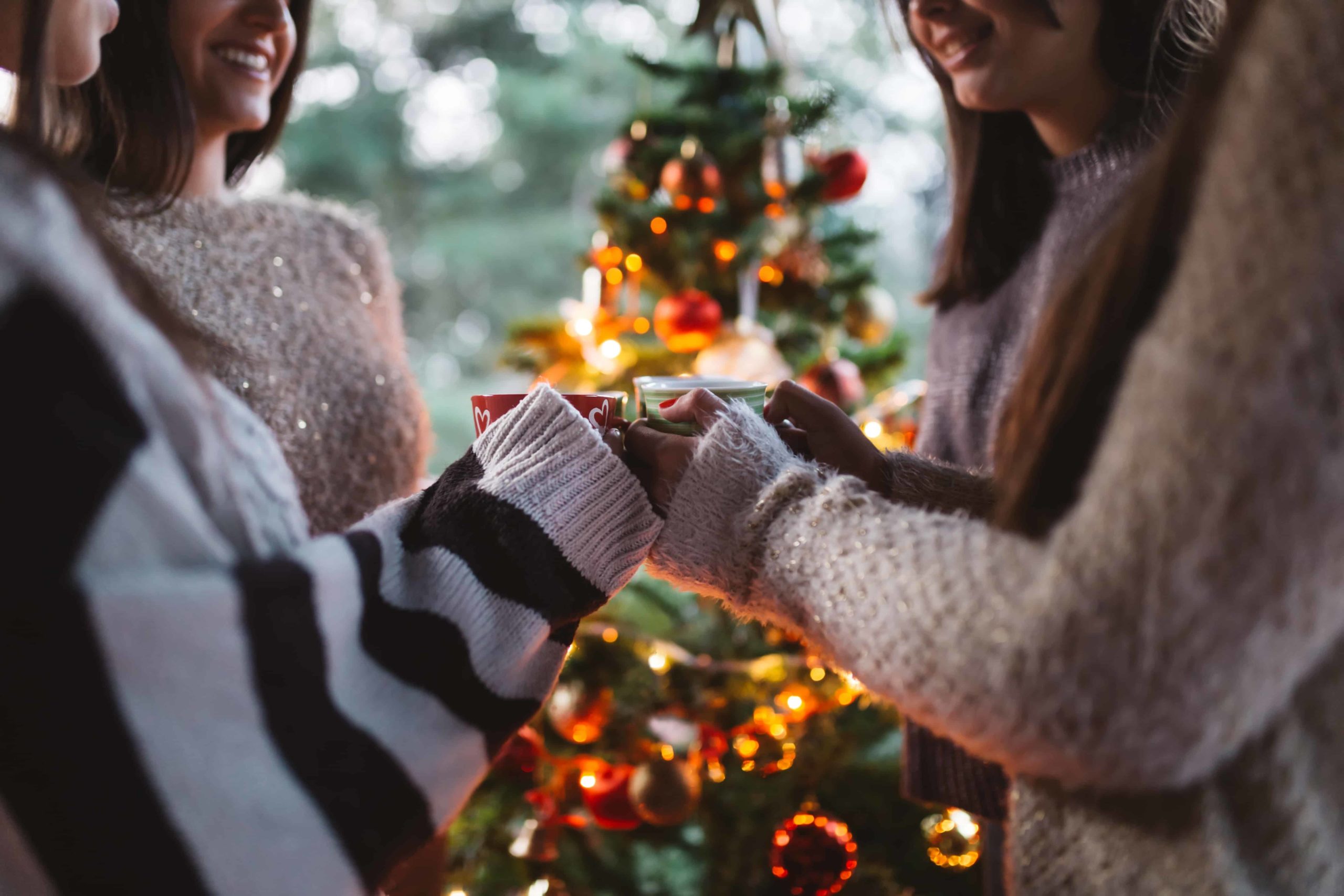 Friends gathered around a Christmas tree