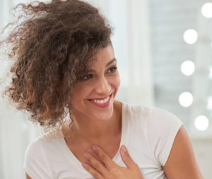 Woman with her hand touching her chest and smiling