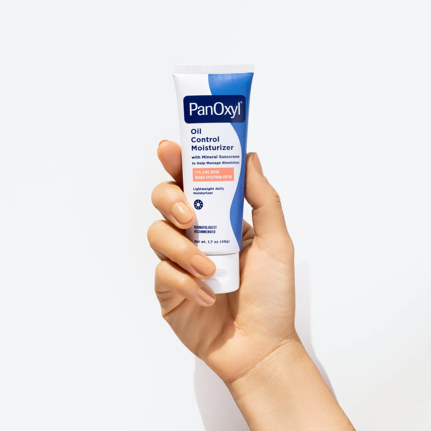 Hand holding a tube of PanOxyl Oil Control Moisturizer