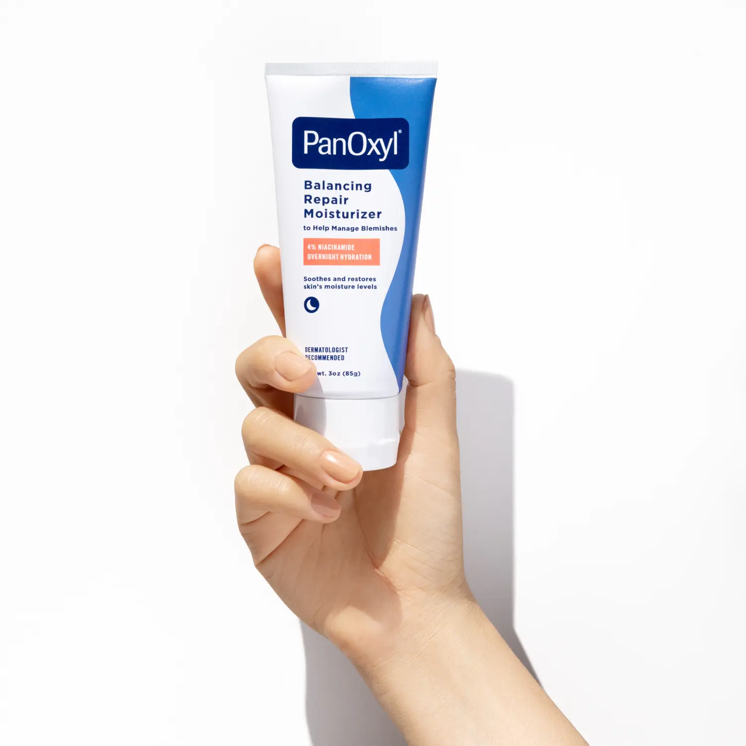 Hand holding PanOxyl Balancing Repair Moisturizer on a white background