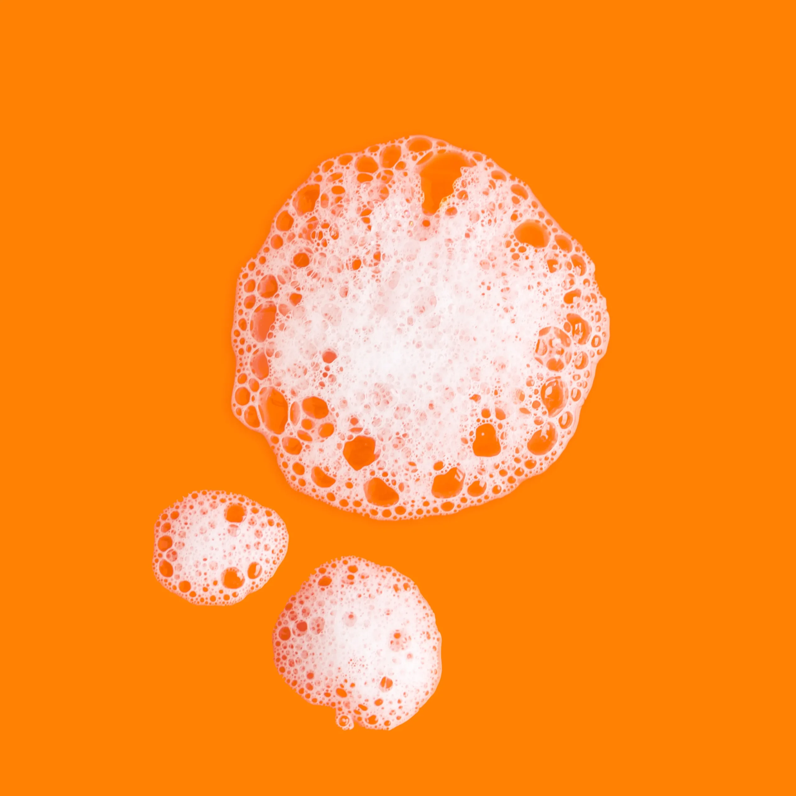 Suds of PanOxyl Acne Treatment Bar on an orange background