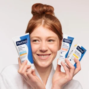 Woman Holding PanOxyl Control Moisturizer and Acne Foaming Wash Tubes.