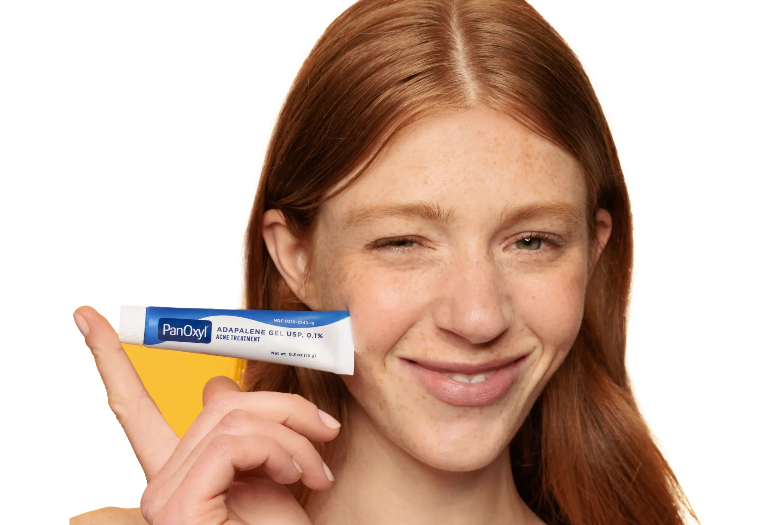 A woman holding PanOxyl adapalene gel USP 0.1% next to her face.