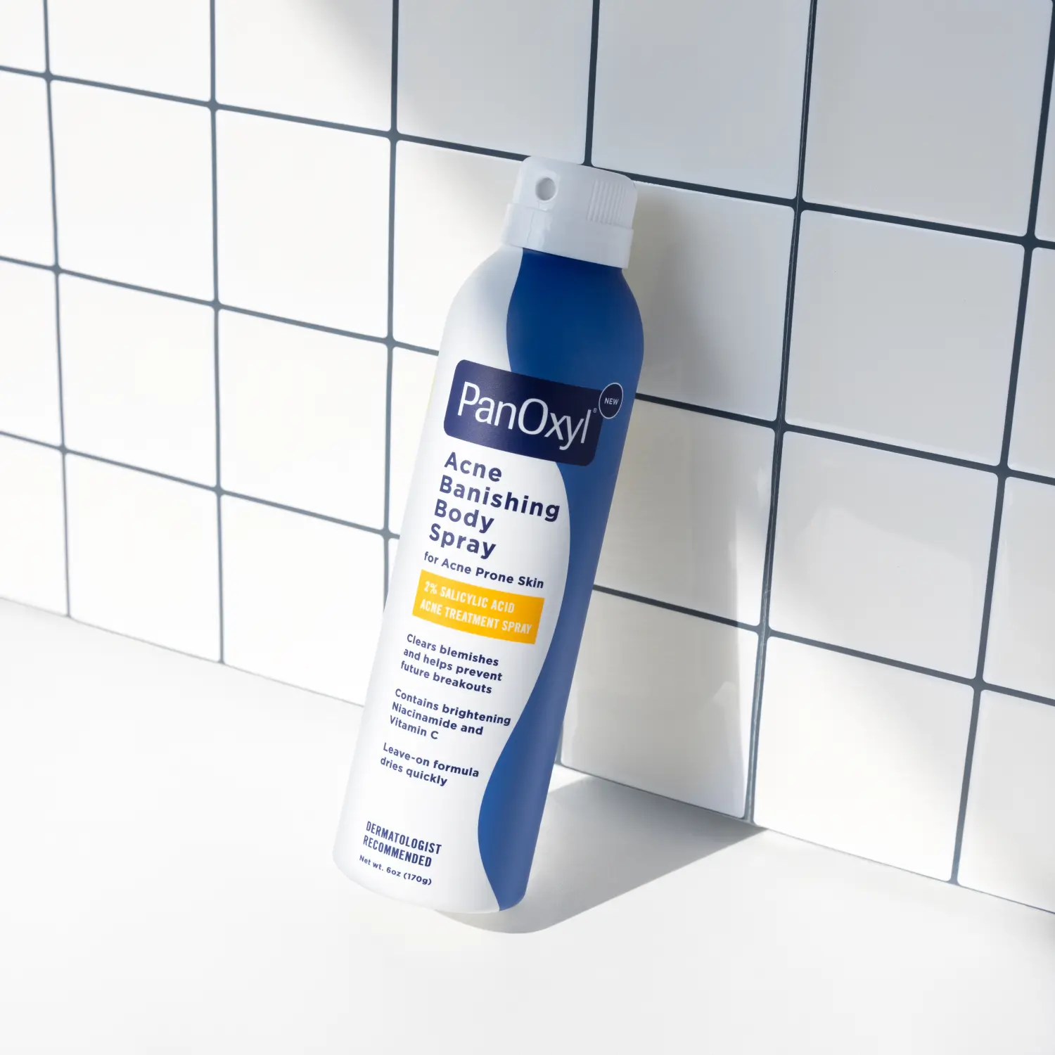 Aerosol bottle of PanOxyl Acne Banishing Body Spray on a white tiled background