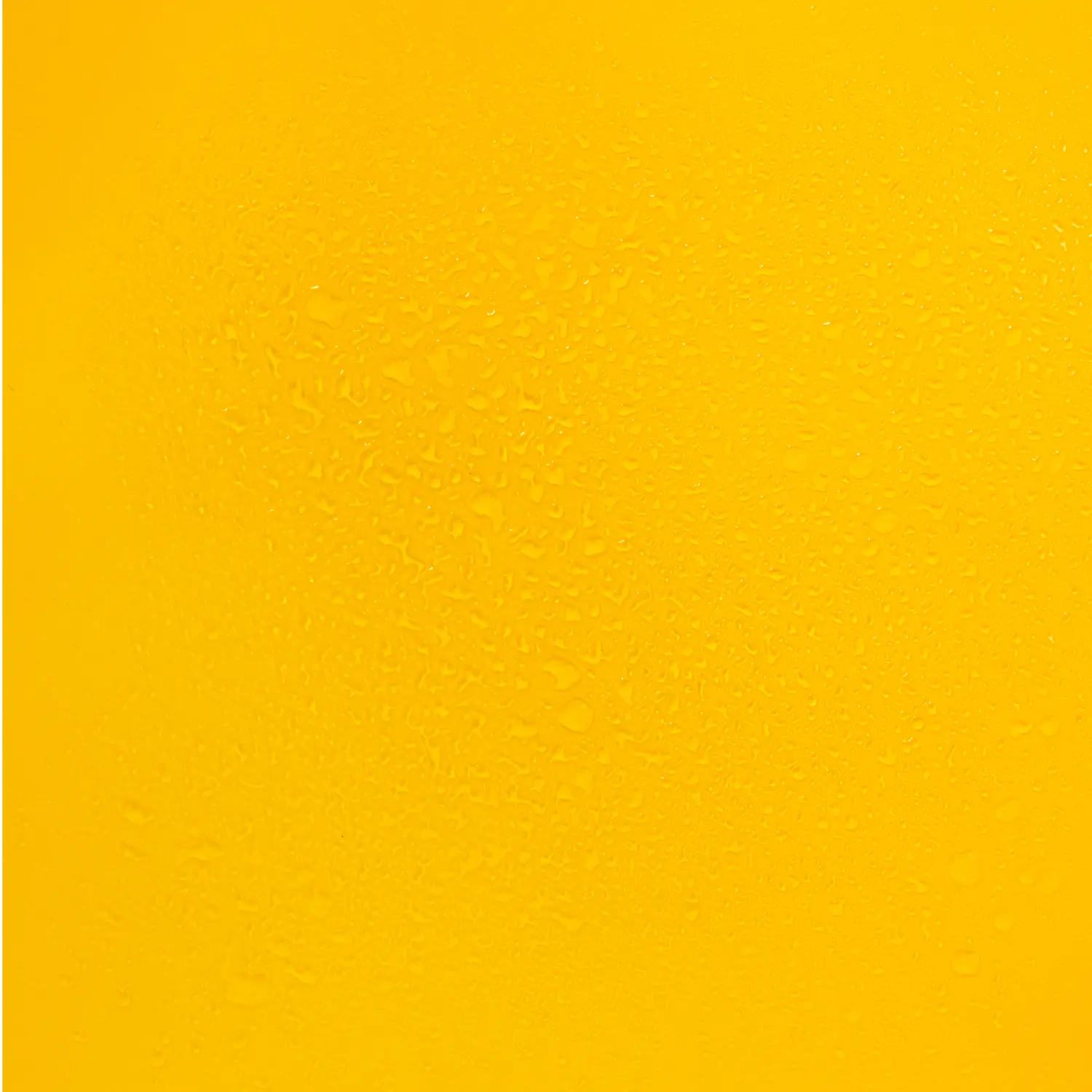 Droplets of PanOxyl banishing body spray on a yellow background.