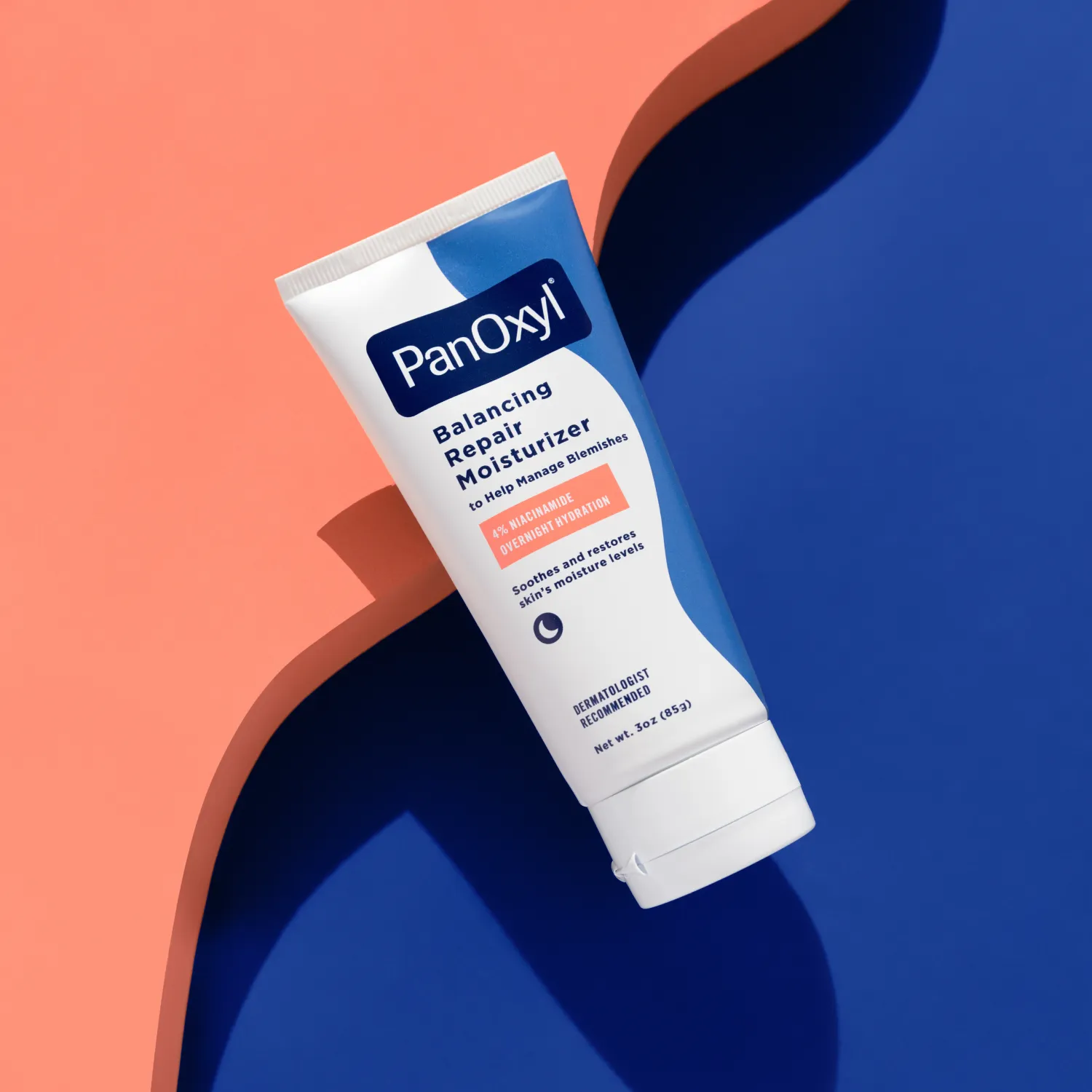 Squeeze tube of a PanOxyl Balancing Repair Moisturizer on a blue and coral background