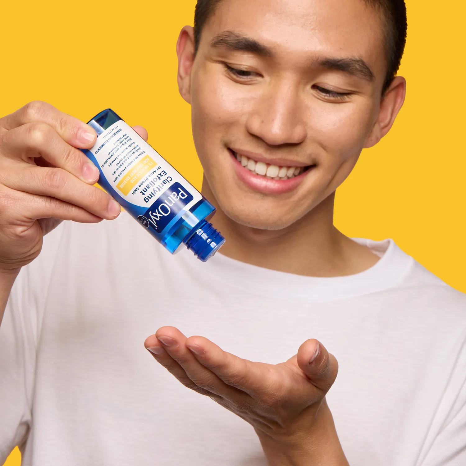 A man dabbing PanOxyl Clarifying Exfoliant on his hand