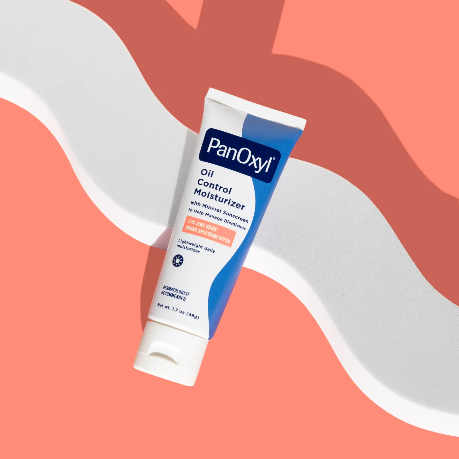 A tube of PanOxyl oil control moisturizer on a coral background.