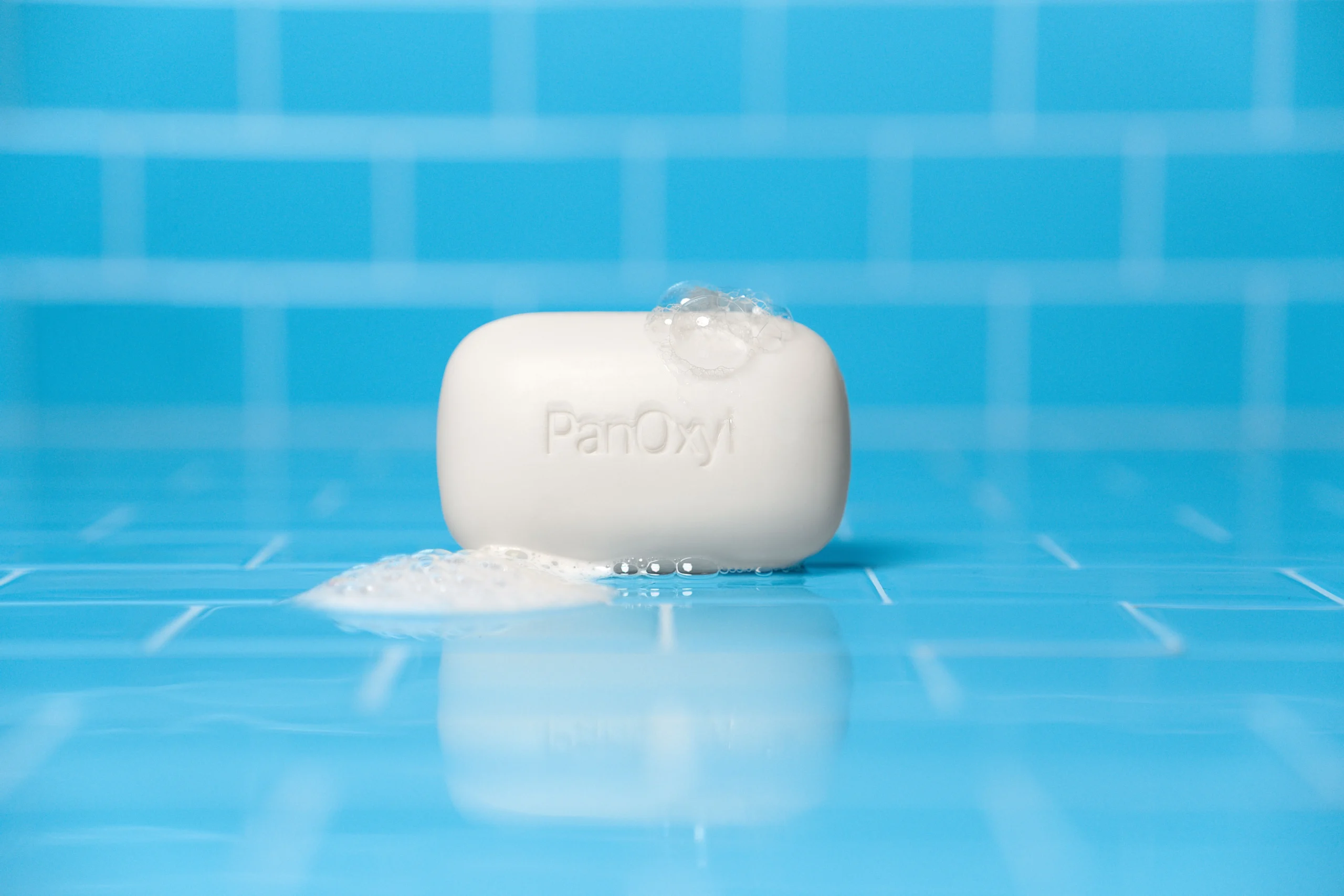 PanOxyl Acne Cleansing bar with 2% Salicylic acid on a blue tile background